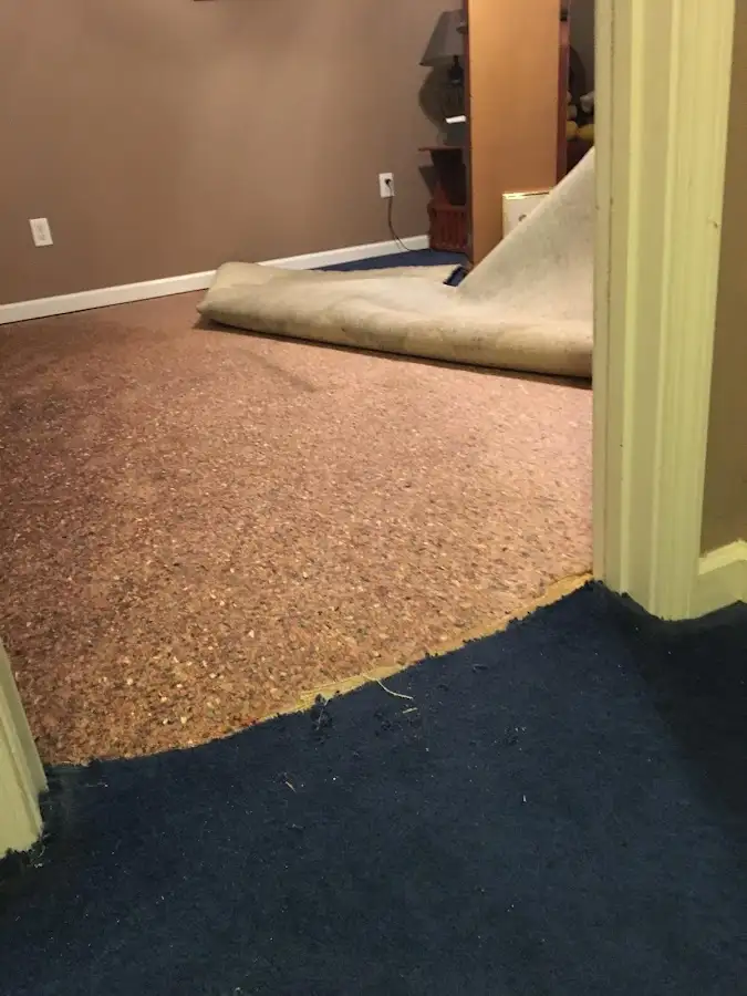 Carpet pad removal revealing water damage during Water Mitigation Services in Tuskegee